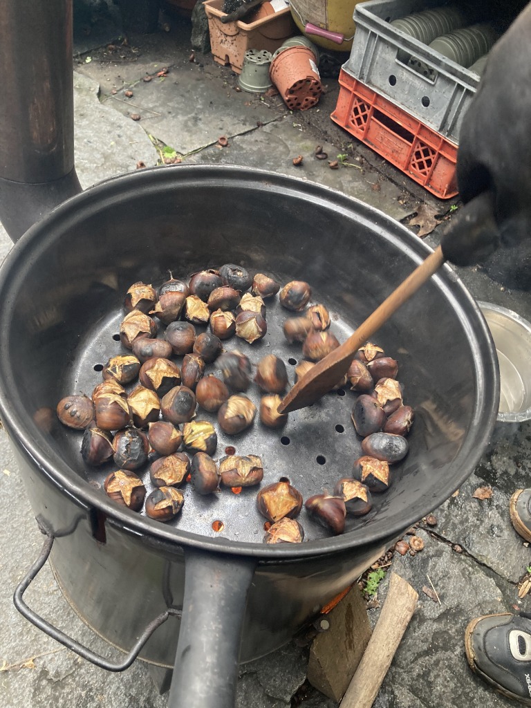 Kastanien rösten über dem Feuer